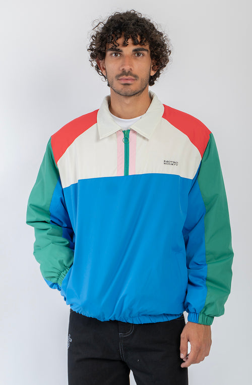Chaqueta Kangaroo color block azul, verde, rojo y marfil con media cremallera y logo Kaotiko Society.