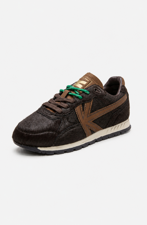 Zapatillas Seattle Pony Brown con acabado de pelo marrón oscuro, logo lateral marrón, cordones verdes y mediasuela en tono crudo.