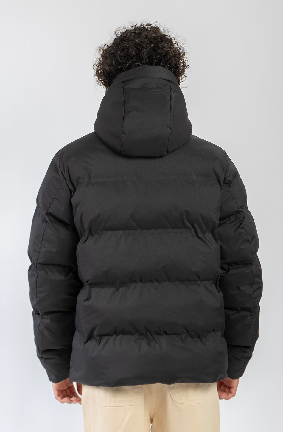 Chaqueta acolchada azul marino oscuro con capucha, cierre frontal y logo Kaotiko bordado en el pecho.