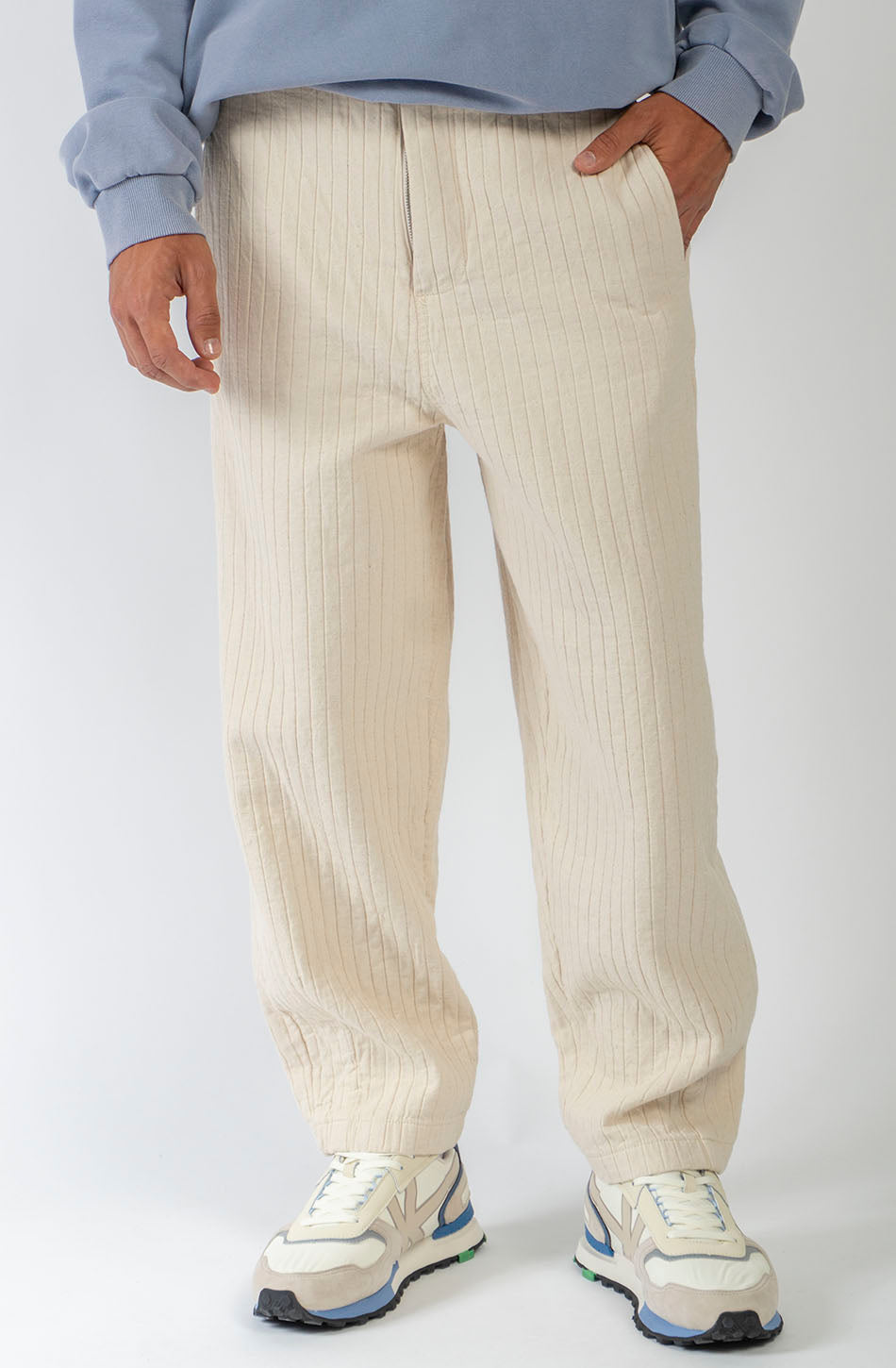 Pantalón unisex color natural con textura de rayas verticales, pierna recta y bolsillos laterales.