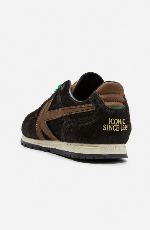 Zapatillas Seattle Pony Brown con acabado de pelo marrón oscuro, logo lateral marrón, cordones verdes y mediasuela en tono crudo.