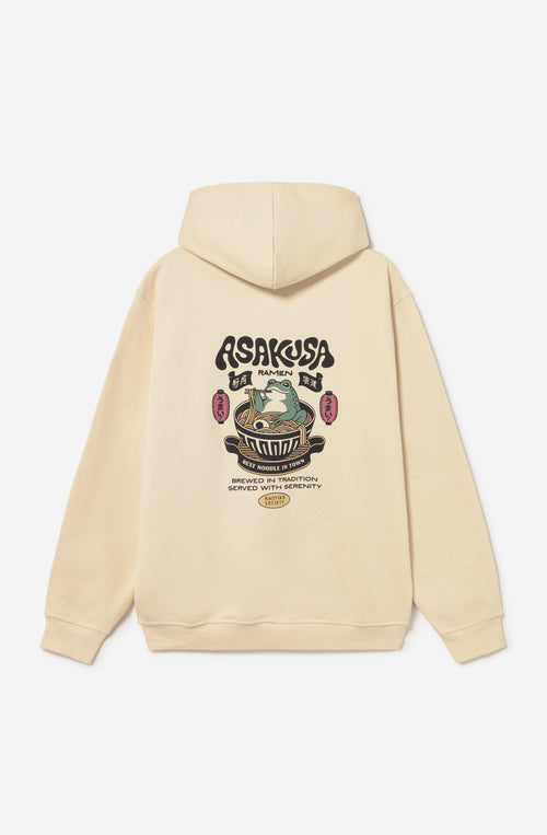 Sudadera oversize unisex de algodón orgánico color crudo con gráfico Asakusa Ramen en el pecho e ilustración de una rana en un bol de ramen en la espalda.