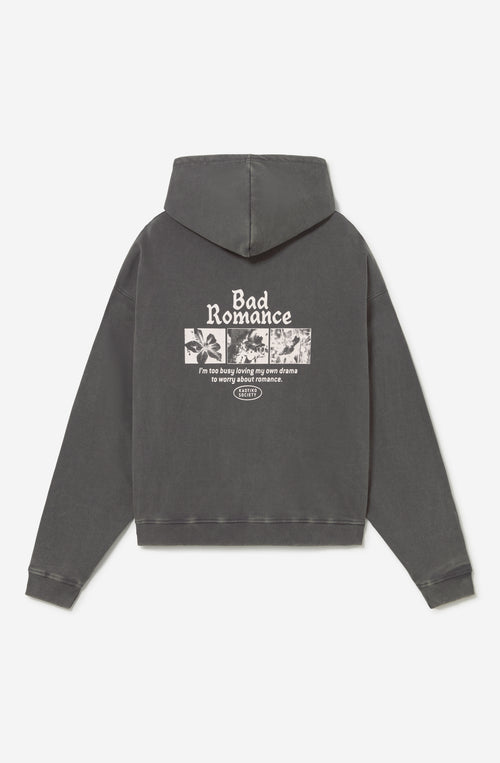 Sudadera oversize gris oscuro con acabado washed, capucha, bolsillo canguro y gráficos Bad Romance de Kaotiko Society.